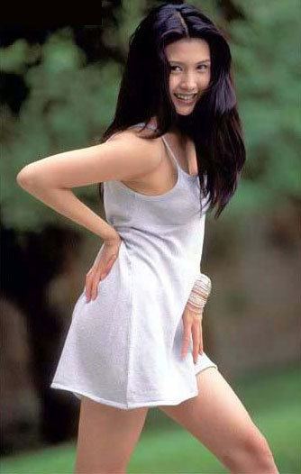 Chingmy Yau smiling while wearing a white sleeveless dress and bracelet
