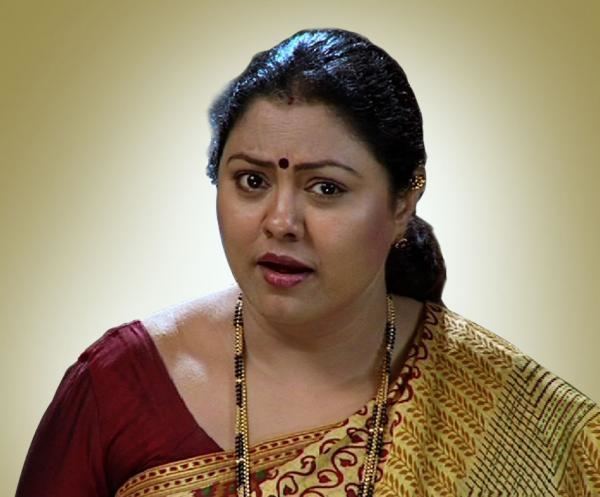 Chitra Shenoy with furrowed eyebrows and wearing a red and yellow saree and necklace with a red mark on her forehead