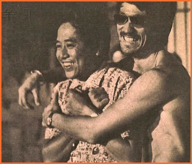 Chor Yuen and Bruce Lee are smiling while Bruce Lee is hugging Chor Yuen from the back. Chor Yuen is wearing a black and white polo shirt while Bruce Lee is topless and wearing sunglasses.