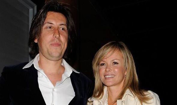 Chris Hughes smiling and wearing a black coat and white long sleeves while Amanda Holden wearing a cream blazer