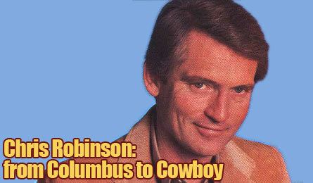 Chris Robinson is smiling, and has black hair, on the lower left is the phrase “Chris Robinson: from Colombus to Cowboy, he is wearing a brown suit.