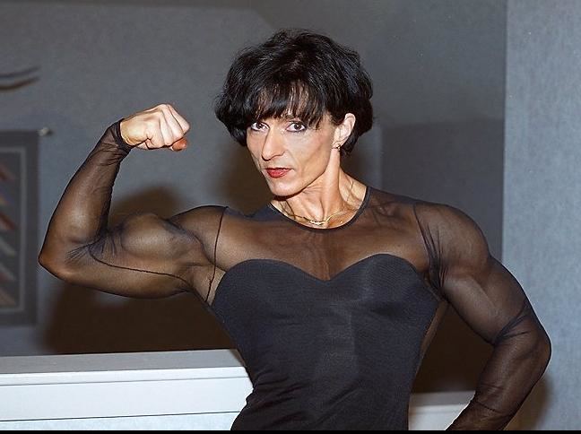 Christa Bauch showing her muscle while wearing black net blouse