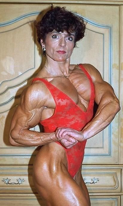 Christa Bauch showing her muscular body while wearing red bodysuit