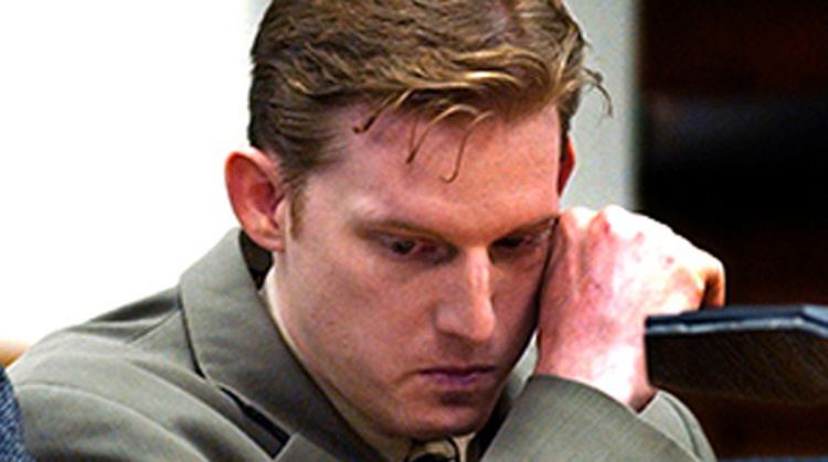 Christian Longo wiping his tears while wearing a gray coat