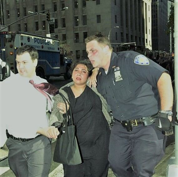 Christopher Amoroso with bruises on his face while saving a man with his pregnant wife. Christopher wearing his uniform while the pregnant woman wearing a black dress with his husband wearing a white long sleeves.