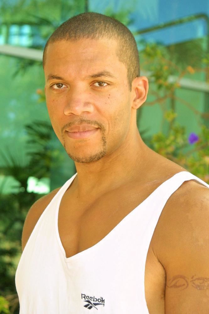 Christopher B. Duncan wearing a white sleeveless shirt outdoors