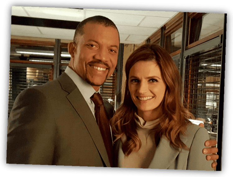 Christopher B. Duncan with Kate Beckett both smiling inside a room