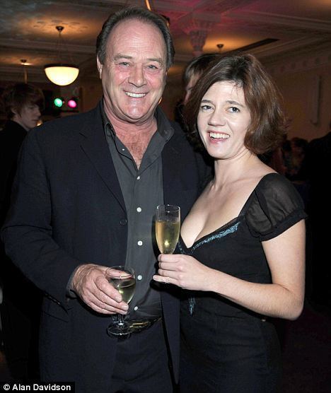 Christopher Cazenove with then girlfriend Isabel Davis enjoying champagne at an event.