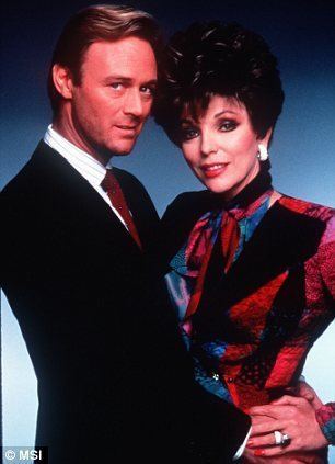 Christopher Cazenove and Joan Collins posing while wearing formal attire for the TV series Dynasty, 1981.