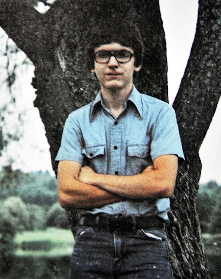 Christopher Thomas Knight at a young age, wearing eyeglasses and a blue polo shirt.