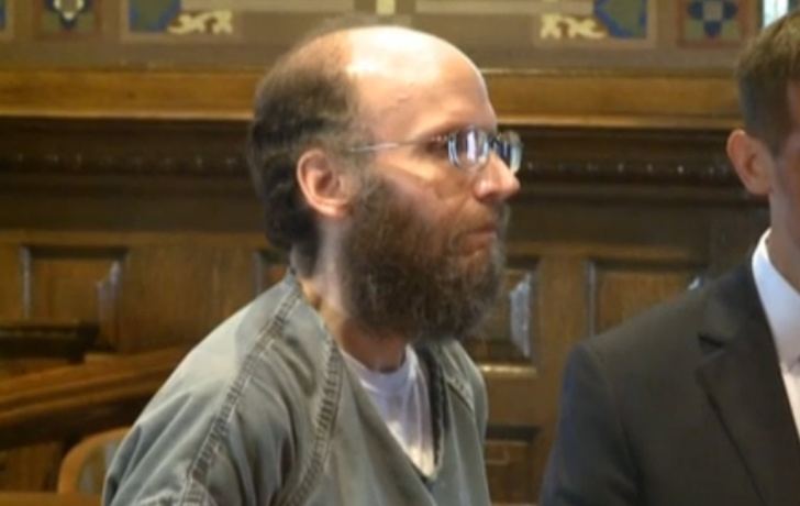 Christopher Thomas Knight with a beard and mustache, wearing eyeglasses inside a court.