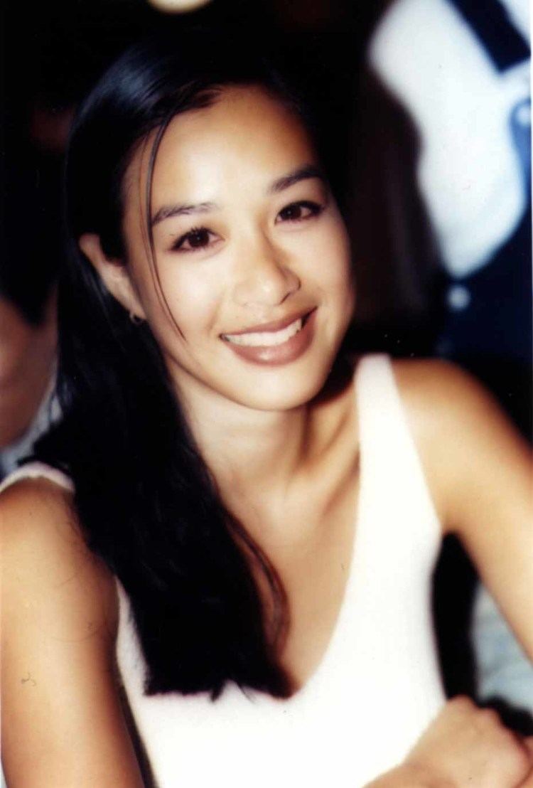 Christy Chung smiling while wearing a white sleeveless blouse