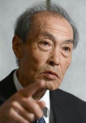 Chūsei Sone is serious, pointing his index finger, has thin elderly gray hair, shaved mustache wearing a white polo with blue necktie under a black tuxedo.