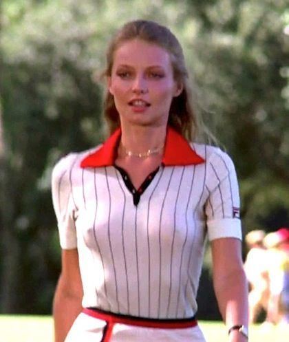 Cindy Morgan walking while wearing a necklace and black and white polo shirt with a red collar