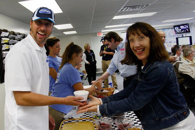 Claire B. Lang smiling while receiving food during an event and wearing a jean jacket.