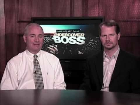 Coby G. Brooks wearing a black coat and gray long sleeves while the man beside him wearing a white long sleeves and necktie