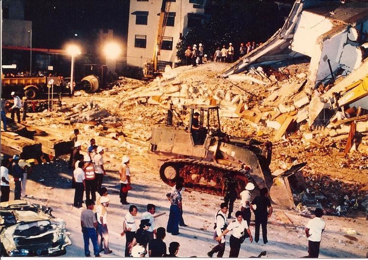 A track-type tractor cleaning away the debris of the collapsed building of Hotel New World