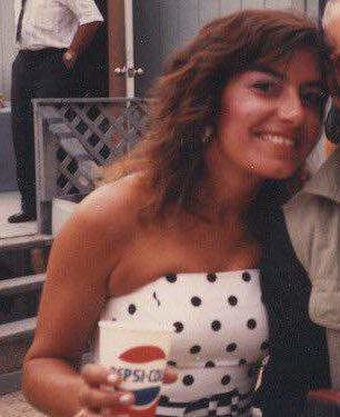 Connie Hamzy smiling and wearing a white strapless shirt with polka dots design and holding a pepsi cup.