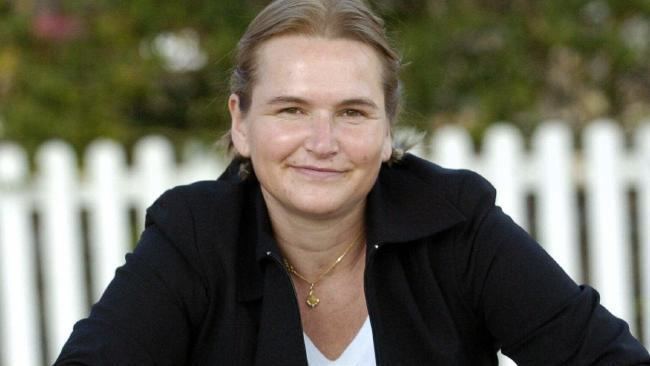 Cornelia Rau smiling, with blonde hair, wearing a black blazer and white shirt.