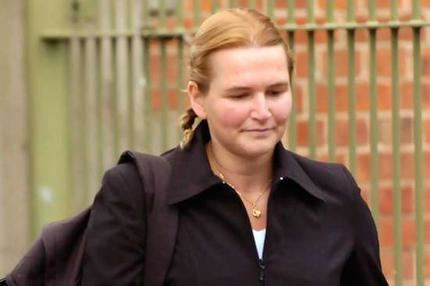 Cornelia Rau with blonde hair, wearing a black blazer and white shirt while carrying a black backpack.