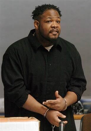 Craig Price speaking with handcuffs while wearing a black long sleeves