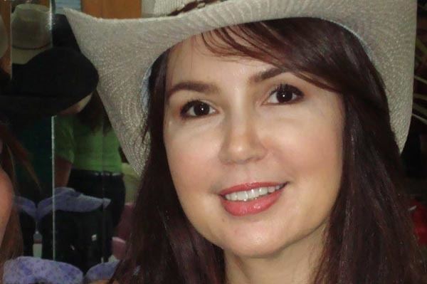Cristina Gonzales smiling and wearing beige hat
