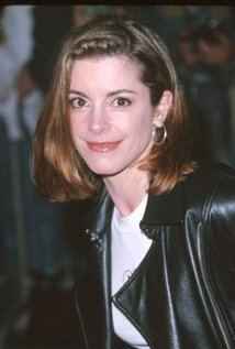 Cynthia Gibb smiling with short hair and wearing a white shirt under a black leather jacket and round silver earrings