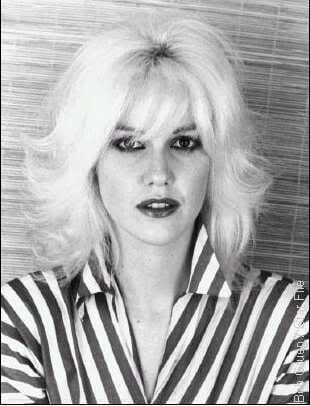 Cyrinda Foxe with blonde hair and wearing striped polo
