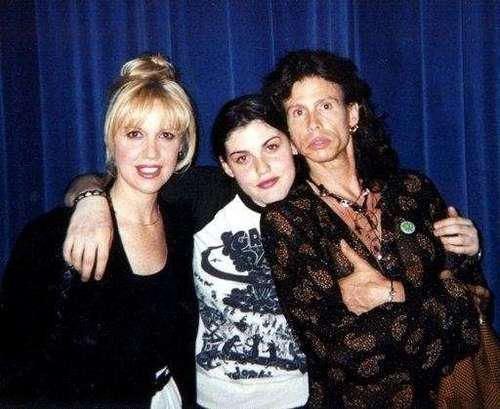 Cyrinda Foxe smiling and wearing black coat beside her is Mia Tyler wearing black and white shirt next to her is Steven Tyler wearing black and brown long sleeves