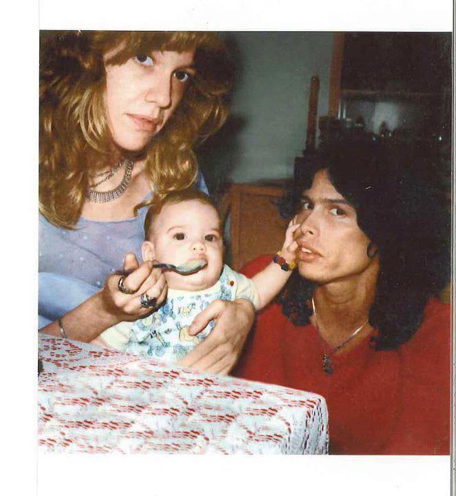 Steven Tyler wearing red shirt and Cyrinda Foxe carrying their daughter Mia Tyler