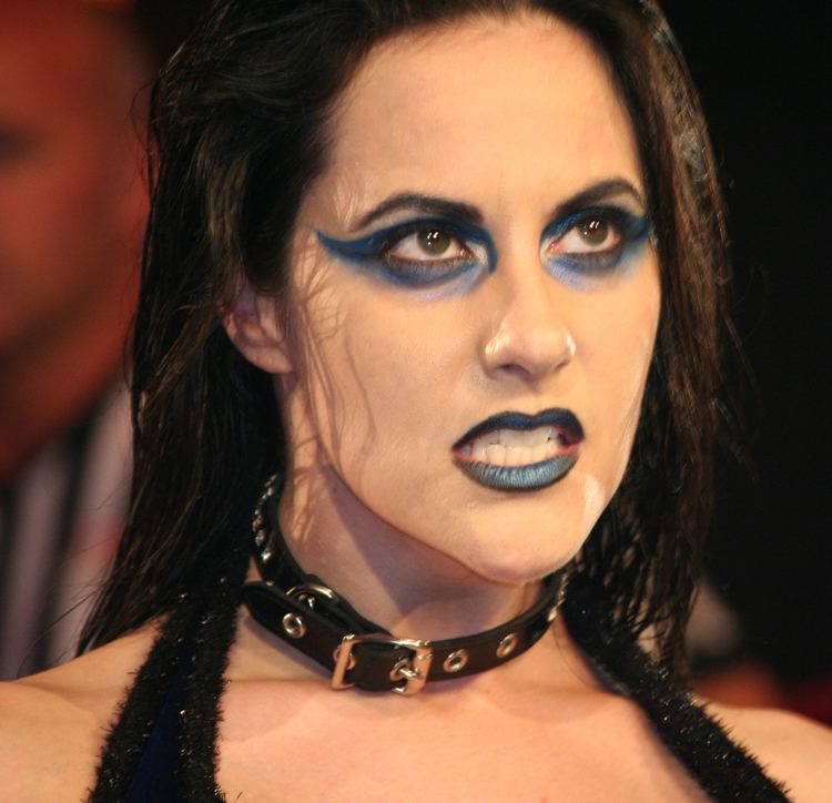 Daffney with a fierce look while wearing a black choker and black sleeveless top