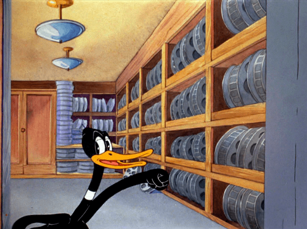 Daffys Inn Trouble movie scenes Daffy exits the film set and then he walks over to a different stage where the film prints are located Daffy looks at all the cans in the storage room as 