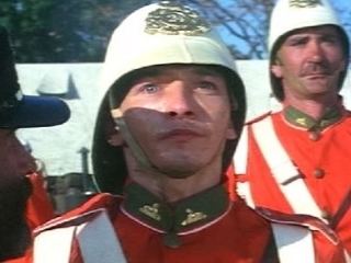 Dai Bradley as Pte Williams looking serious with another soldier in the background in the 1979 film Zulu Dawn and wearing a soldiers uniform