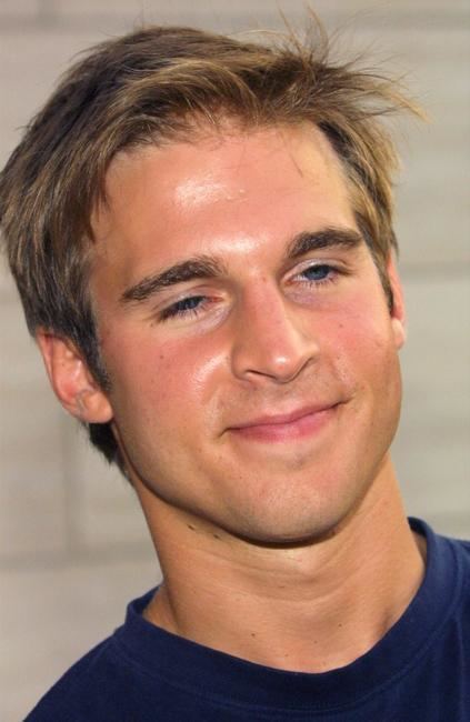 Daniel Letterle smiles while wearing a dark blue shirt