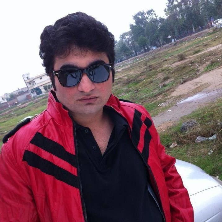 Danish Nawaz with curly hair and wearing black shades, red jacket, and black polo shirt