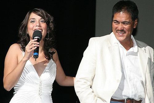 Dante Varona smiling while wearing a white coat and white long sleeves while her daughter, Tanya Varona wearing a white sleeveless dress