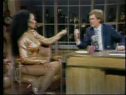 Darcel Leonard Wynne wearing a sexy dress and high heels during her interview with David Letterman wearing a blue suit and a tie.