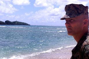 Dave Karnes looking afar while he is at the beach, wearing a marine uniform