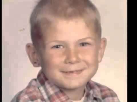 Young Dave Pelzer smiling while wearing a white and red checkered polo