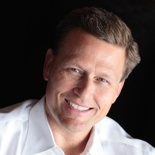 David Baldacci smiling while wearing a white polo