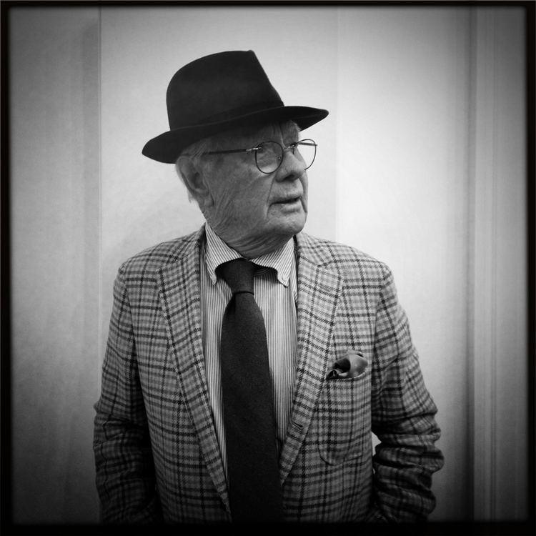 David Hamilton (photographer) wearing a shirt, a suit, a pair of eyeglasses, a tie, and a hat (a black and white photo)