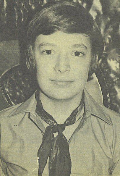 David Henesy smiling closed mouth and wearing a collared shirt and a neckerchief.