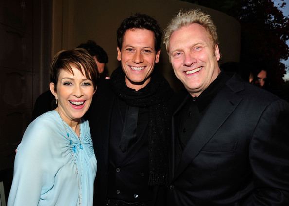 David Hunt smiling, with blonde hair, and wearing a black suit together with Patricia Heaton wearing a light blue dress and Ioan Gruffudd wearing a black suit.