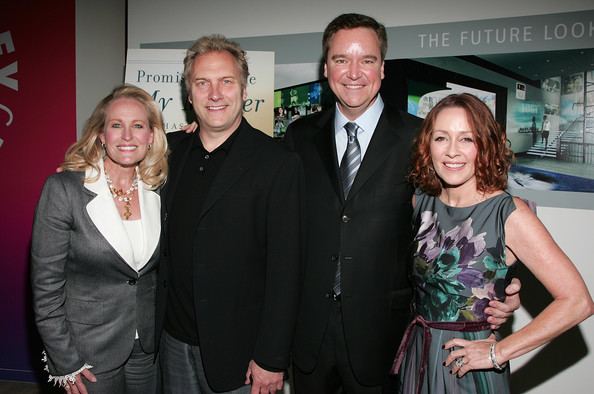 David Hunt with blonde hair and wearing a black suit, Patricia Heaton wearing a floral sleeveless dress, Sam Haskell smiling and wearing a black suit and a tie, and a lady with blonde hair and wearing a suit.