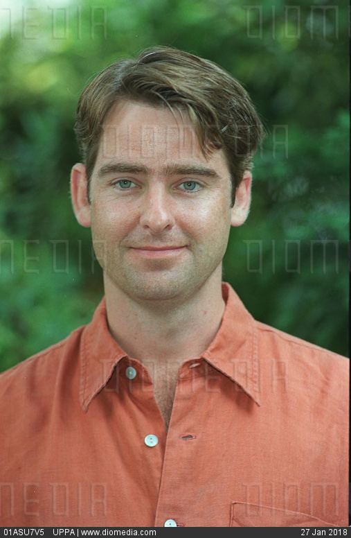 David Michaels smiling in an orange shirt
