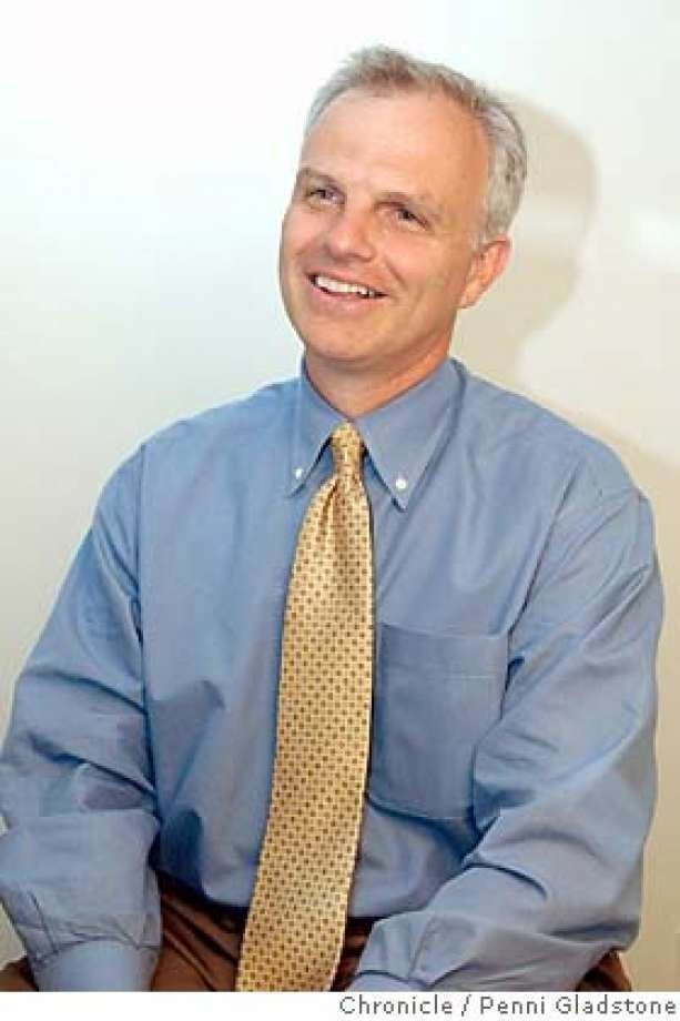 David Neeleman wearing blue long sleeves, a yellow tie, and brown pants.