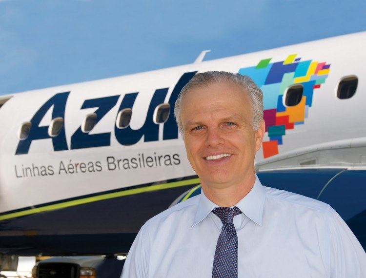 David Neeleman wearing white long sleeves and a blue tie with an airplane on his back.
