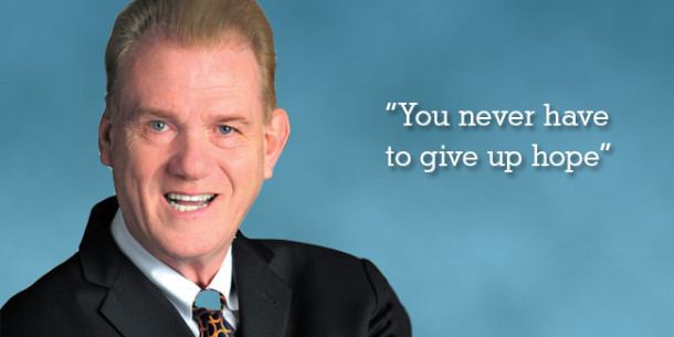 In a cyan background, on the left David Ring is happy, mouth half open,, has brown hair, wearing a white polo with black printed necktie under a black coat, at the right is a wordings “You never have to give up hope”