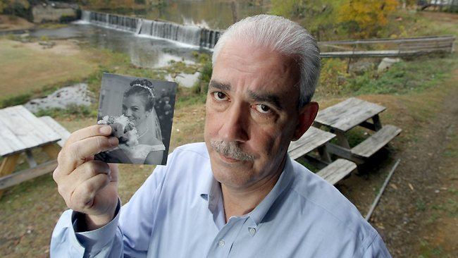 Tina Watson's father Tommy Thomas holding a photo of his daughter Tina on her wedding day