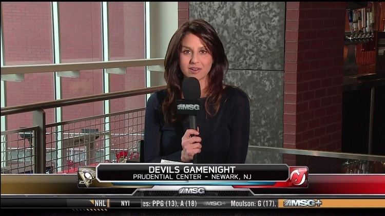 Deb Placey delivering a news report while wearing a black long sleeve dress